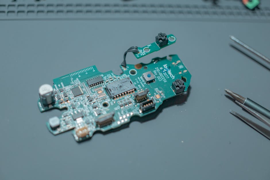 A cluttered electronics repair shop with various computer parts, tools, and components scattered around