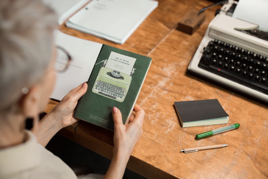 Author working at computer with books, showing the transition from manuscript to published work