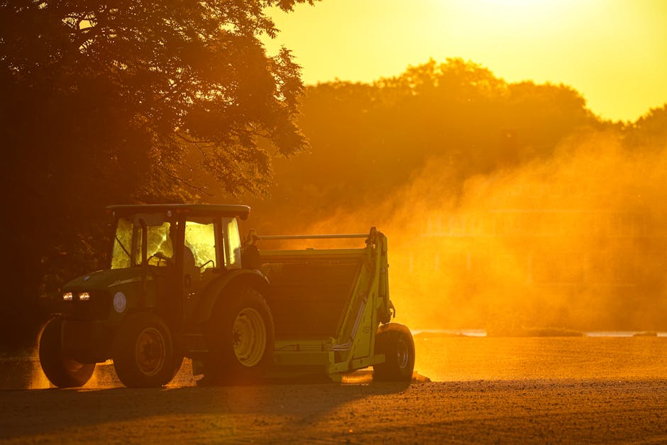 A farmer's hands holding a wrench near a large piece of agricultural equipment, golden hour lighting, dusty field background