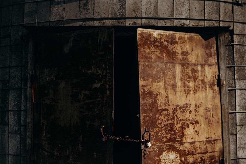 A house with a padlock overlaid on the front door, symbolizing homeowners locked into low mortgage rates, muted tones, wide angle, photorealistic