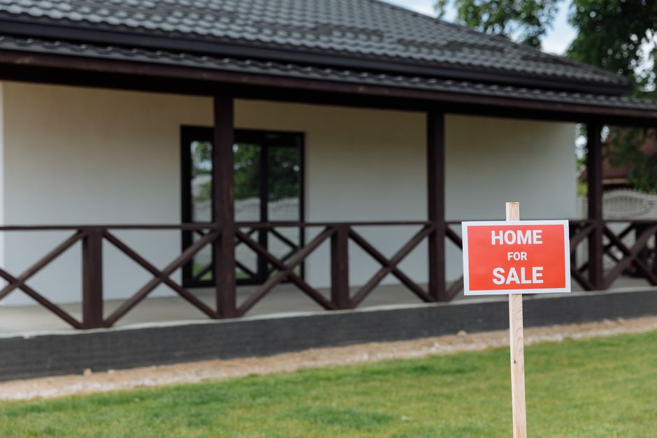 A family looking at a house for sale sign with price tag, worried expressions, suburban street, natural lighting, cinematic composition