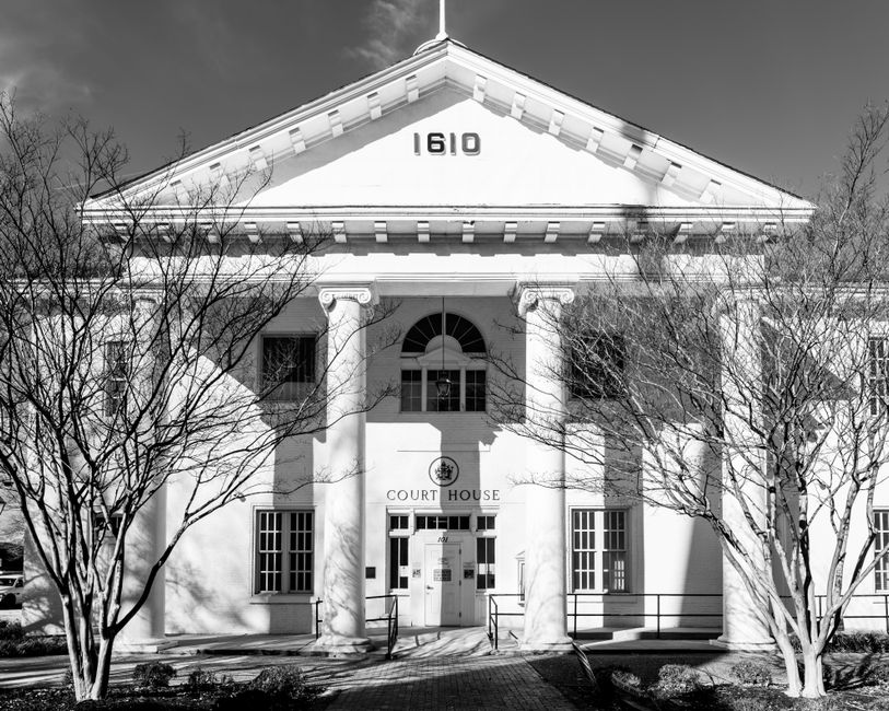 A courthouse with digital circuit patterns overlaid, representing surveillance law and civil liberties in conflict