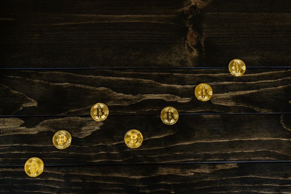 A worn leather wallet next to a glowing Bitcoin symbol, dimly lit on a wooden table — representing old money meeting new freedom tech