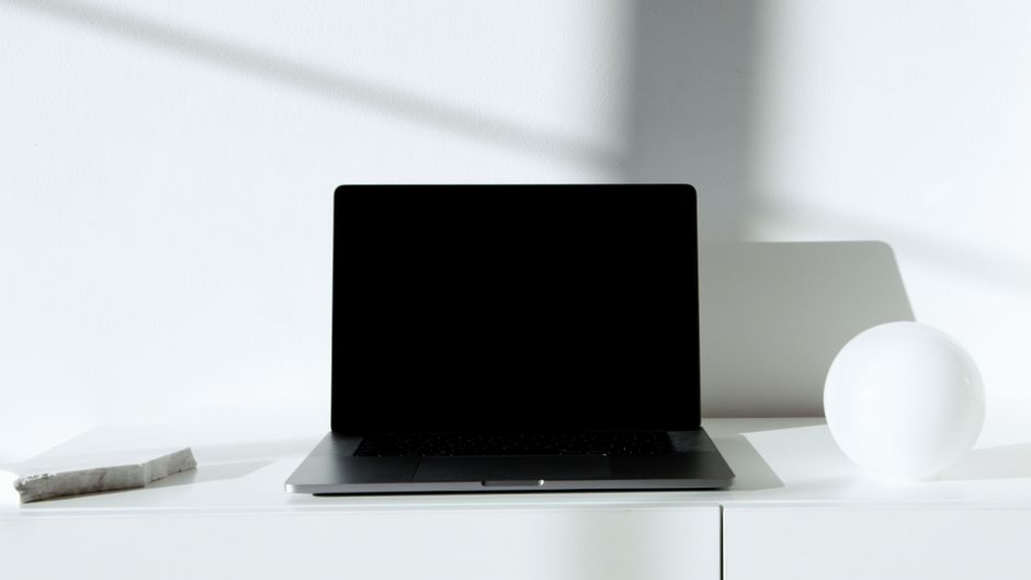 A clean home office desk with a laptop connected to a 10G ethernet module, professional lighting, minimalist aesthetic